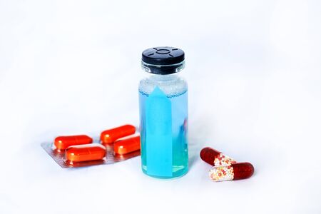 Coronavirus vaccine bottle on white background with pillsの写真素材