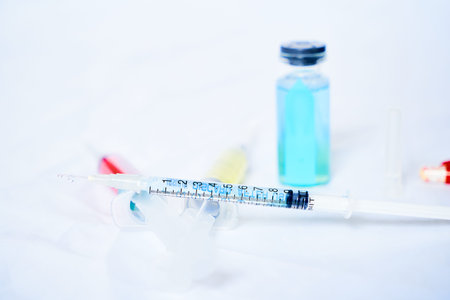 A syringe for injection with a coronavirus vaccine, antiviral tablets and 2 syringes with red and...