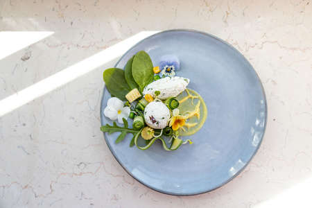 Healthy, decorative summer salad with organic rucola and spinach, goat cheese, mustard sauce, edible flowers violasの写真素材