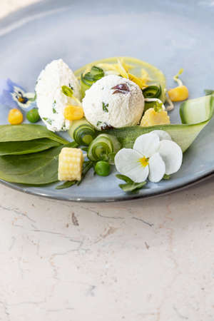 Healthy, decorative summer salad with organic rucola and spinach, goat cheese, mustard sauce, edible flowers violasの写真素材
