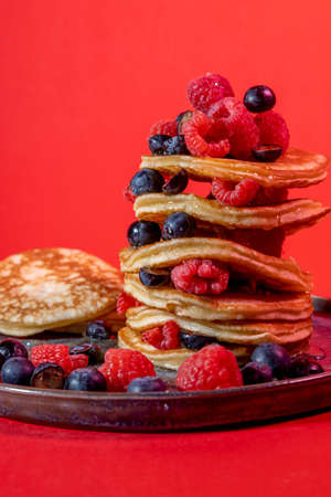 American pancakes with berries on a colorful background and hard light . Studio shootingの写真素材