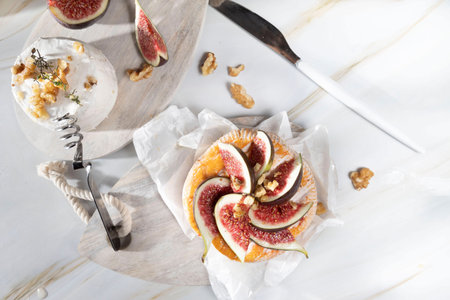 Camembert cheese with figs, walnuts, thyme and honey on a white marble table .French dessertの写真素材