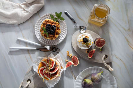Camembert cheese with figs, walnuts, thyme and honey on a white marble table .French dessertの写真素材