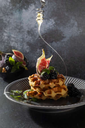 Whole wheat waffles with honey and figs on dark background. Top view, copy space for text.の写真素材
