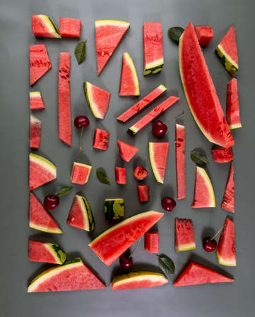Beautiful pattern with fresh watermelon slice and cherries on green background.の写真素材