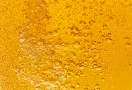 Close-up of golden bubbles in beer.の写真素材