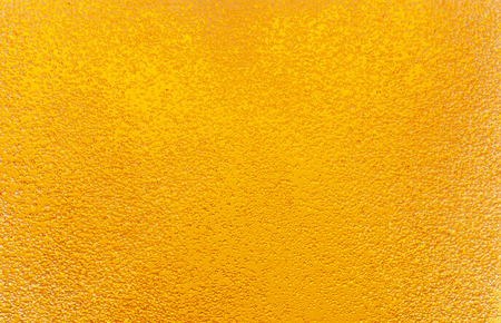 Close-up of golden bubbles in beer.の写真素材