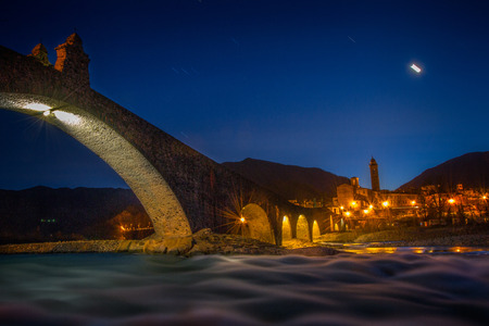 View of medieval Italian town with its important roman bridge in the early nightの写真素材