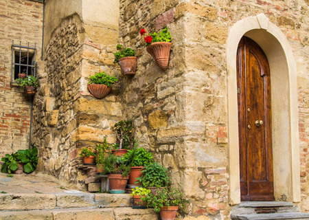 Corner in a Tuscany town with a lot of flowers and plants, just near a door entranceのeditorial素材