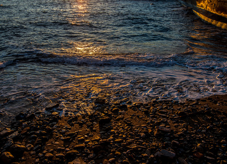 Waves on the shoreline of Tuscany coast at sunsetの写真素材