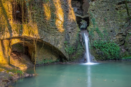 Ruins of a water mill in Tuscany with a waterfall That passes throughの写真素材