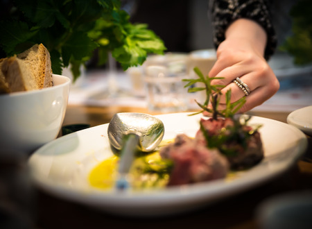 Hand gently takes a intentionally blurred tray of foodの写真素材