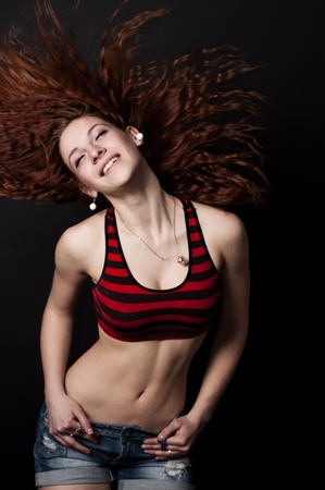 Young sexy dancing woman hiphop black backgroundの写真素材