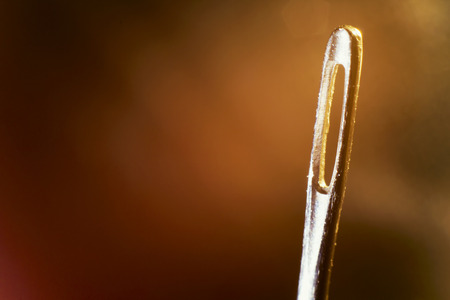 Sewing needle close up on warm colors background with light leaksの写真素材