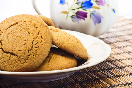 Some molasses cookies on plate with milk pot on backgroundの写真素材