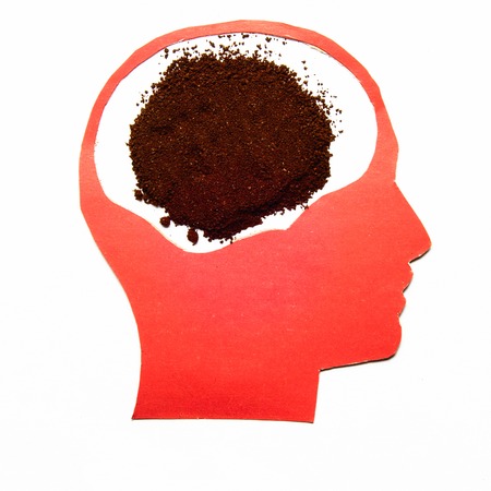 Red paper human head with coffee pile inside on white backgroundの写真素材