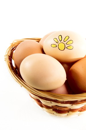 Nice eggs with sun sign in basket on white isolated backgroundの写真素材