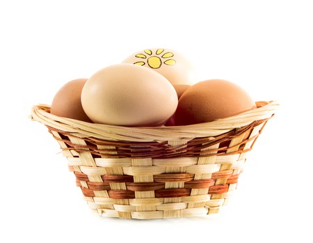 Nice eggs with sun sign in basket on white isolated backgroundの写真素材