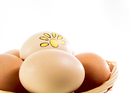 Nice eggs with sun sign in basket on white isolated backgroundの写真素材