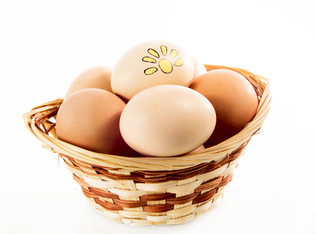Nice eggs with sun sign in basket on white isolated backgroundの写真素材
