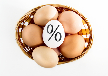 Nice eggs in basket with procent sign on white isolated backgroundの写真素材