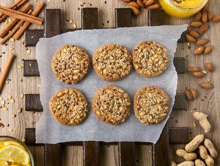 Oatmeal cookies with grain and fiber and nuts on white paperの写真素材