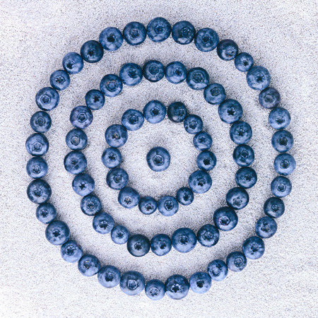 Blueberries on white sandの写真素材