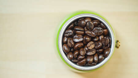 Top view coffee beans in filter cup of a moka pot on a wood background before finely ground.の写真素材