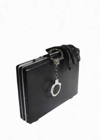 Attache case with black gloves and attached handcuffs on white の写真素材