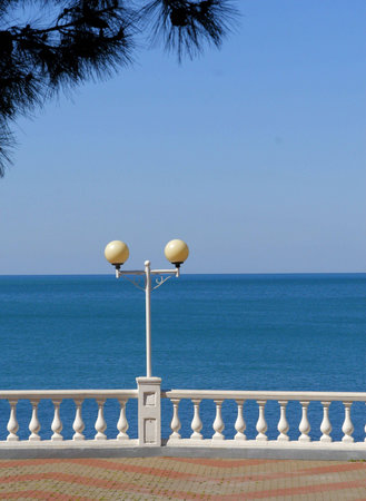 Photo of white balustrade and lantern wihith bllue sea as a backgroundの写真素材