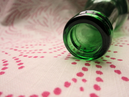 Soft green and pink hues of bottle on dotted cotton napkin.の写真素材