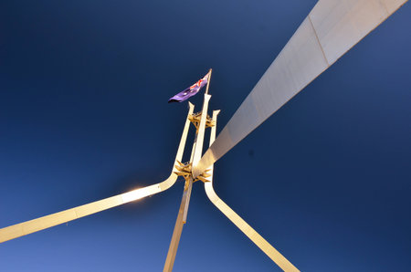 Australian flag on the sky on top of steel building structure of parliament houseの写真素材