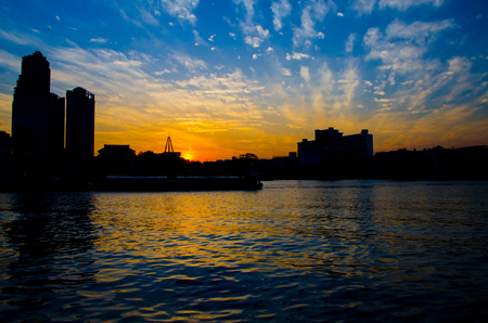 Enjoying romantic sunset at the waterfront city center with river flow and tall buildingsの写真素材