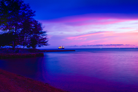 Gorgeous romantic purple orange sunset on a beach harbor in Indian Pacific sea ocean for family school children and couple honeymoon vacationの写真素材