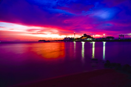Gorgeous romantic purple orange sunset on a beach harbor in Indian Pacific sea ocean for family school children and couple honeymoon vacationの写真素材