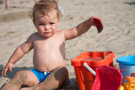 child playing on the beach with bucketの写真素材