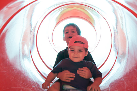two children in red tube slideの写真素材