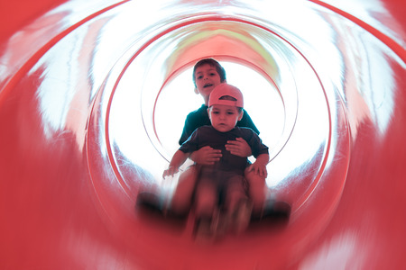 two children in red tube slideの写真素材