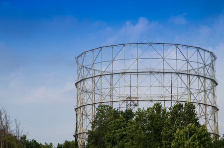 old disused gasometer metal covered with vegetationの写真素材