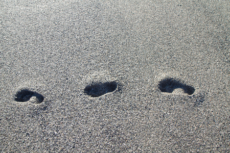backgroun footprints on the beach of gray stonesの写真素材