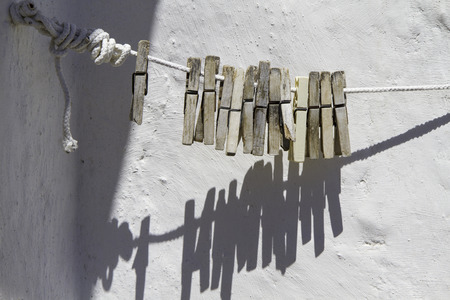 detail clothespins on rope on background wall whiteの写真素材