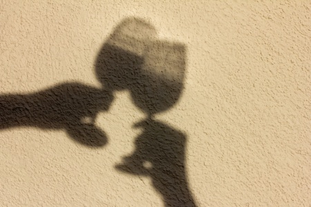 Shadow of two glasses with handsの写真素材