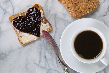 A slice of toast with heart-shaped jam spreadの写真素材