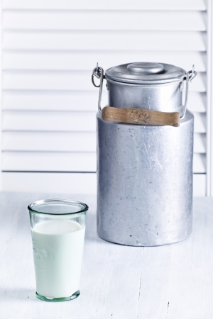 A glass of milk before a milk pot from enamelの写真素材