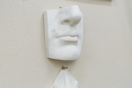 On the wall hangs a plaster sculpture of the nose and lipsの写真素材