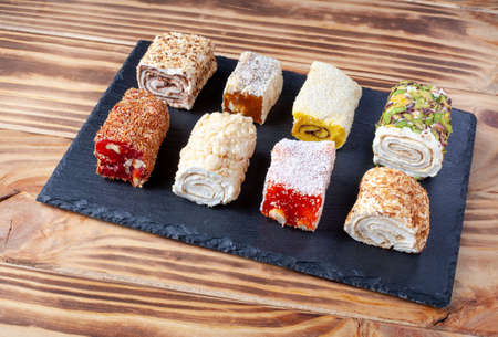Turkish delight. Set of assorted Turkish delights with various flavors cream-filled. Lokum rolls covered nuts and sugar powder. Fruit jelly candy with hazelnut. close upの写真素材