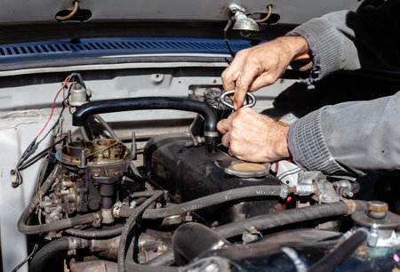 the mechanic uses a screwdriver to disassemble old engine. DIY repair. troubleshooting process. under the hood workingの写真素材
