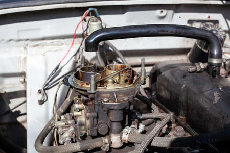 Disassembled carburetor on old engine without top and air filter. Carburettor motor Maintenance and repair. Cleaning fuel system. Close upの写真素材