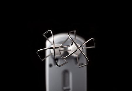 Bottom view on stirring whisks of hand mixer wih narrow DOF, focused on metal part