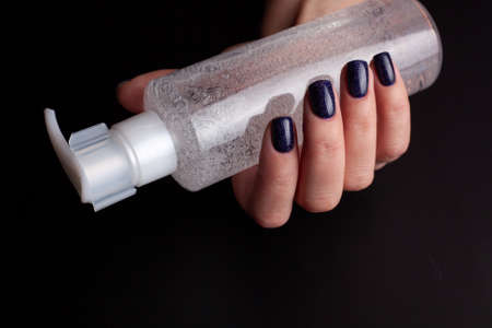 Cosmetic product for makeup remove. Clear liquid with small air bubbles. Bottle with dispenser. in woman handの写真素材
